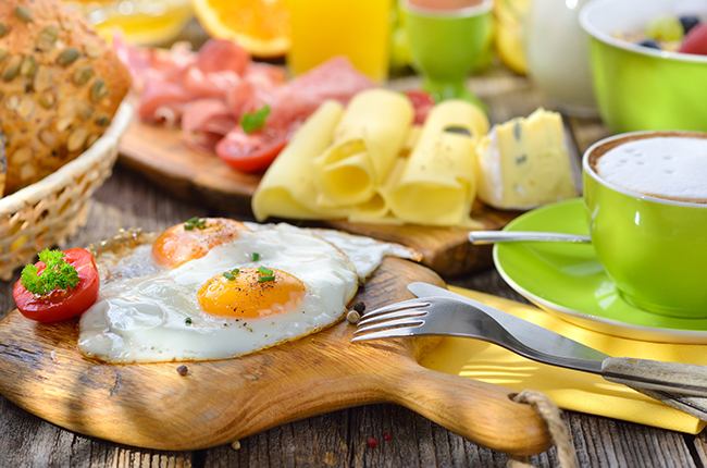 Gedeckter, rustikaler Frühstückstisch im Sonnenlicht mit Spieg
