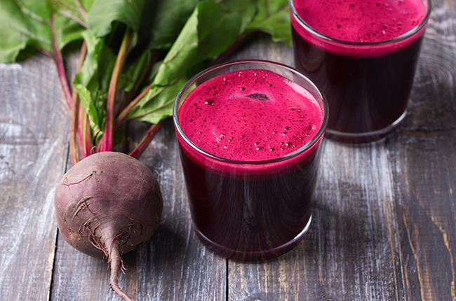 Fresh beet juice in glasses on a wooden background, selective fo
